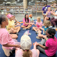 Camp GOTR participants play a game seated on the floor in a circle
