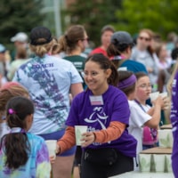 Adult 5K participant smiles while running outdoors through the city